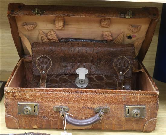 An early 20th century crocodile skin briefcase and a suitcase length 49cm